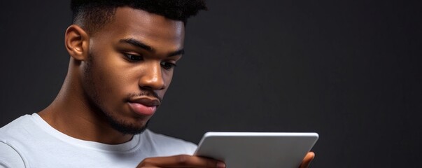 Young man looking intently at a digital tablet screen