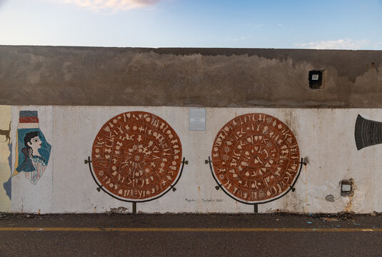 Heraklion, Crete, Greece - October 2, 2023: A picture of The Phaistos Disk and The Arkalochori Axe mural at the Heraklion breakwater, created by Michalis Pavlakis in 2023.