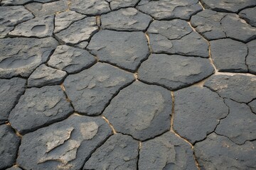 Dry cracked basalt rock surface with an irregular natural pattern