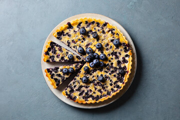 Blueberry tart with vanilla custard cream. Grey background. Close up. Top view.
