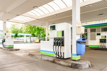 Fuel dispensers at a modern gas station with canopies during daylight in a suburban area