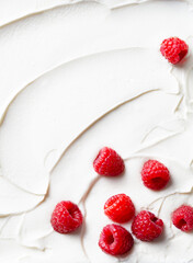 Yogurt, cream with fresh raspberries background. Copy space. Top view.