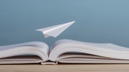 A paper airplane taking off from an open book symbolizes learning as a journey to success. Sharp depth and well-balanced contrast.