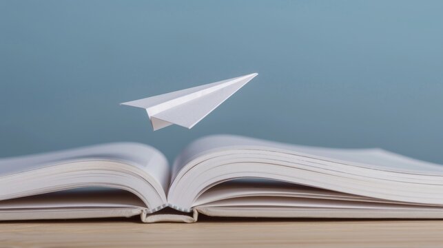 A paper airplane taking off from an open book symbolizes learning as a journey to success. Sharp depth and well-balanced contrast.