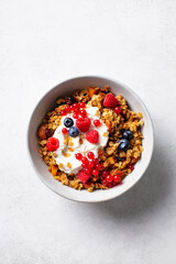 Healthy breakfast. Granola, muesli with yogurt and fresh berries. Grey background. Top view.