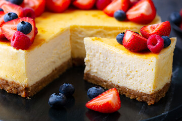 Cheesecake dessert with fresh berries. Dark background. Close up.