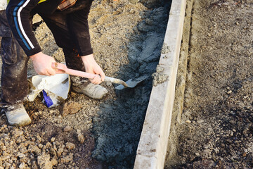 Builder mixes cement to create a sturdy foundation for new sidewalk