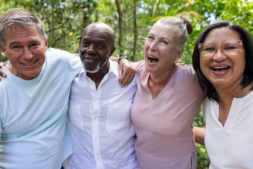 Diverse group of senior friends enjoying outdoor nature walk, smiling and embracing