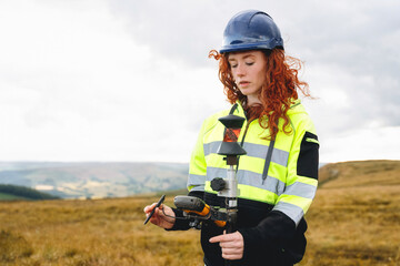 Young woman conducting land survey with specialized equipment in an open field