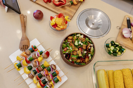 Colorful vegetable skewers and fresh salad on kitchen counter for healthy meal
