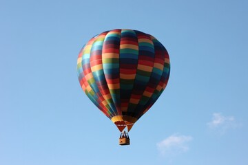 Fototapeta premium vividly colored hot air balloon floats gracefully against clear blue sky showcasing intricate patterns and vibrant