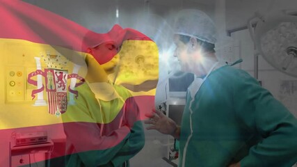 In operating room, surgeons discussing with Spanish flag animation overlaying them - Powered by Adobe