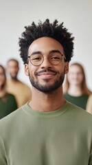 Obraz premium Confident Young Man with Glasses Smiling in Group Setting