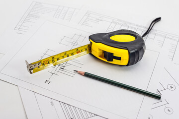 Measure tape placed on construction drawing with pencil during design planning process