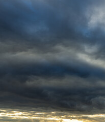 Obraz premium The sky is dark and cloudy, with a few rays of sunlight peeking through