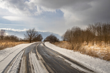 Road with snow on it and a cloudy sky