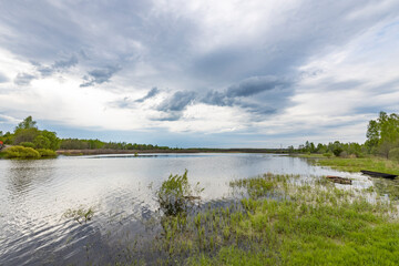 A lake with a cloudy sky in the background