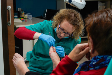 Chiropodist trimming the toenails of a retired woman