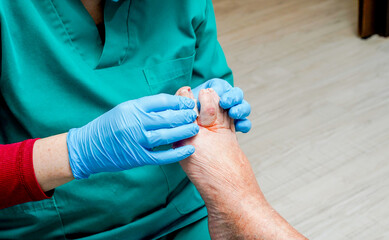 Chiropodist examining the feet of a retired woman