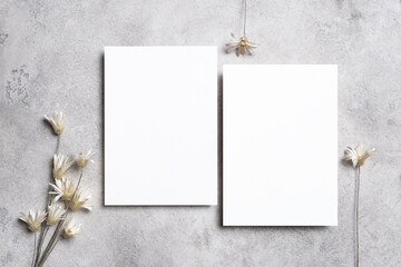 Blank wedding invitation or greeting card mockup with dried flowers decoration, two white cards mock up with copy space