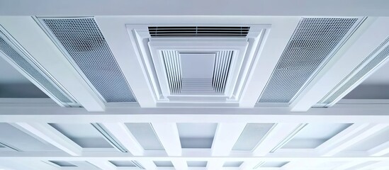 Obraz premium A photograph of a white ceiling with square air vent extrusions, showcasing the intricate design and detail in high resolution.
