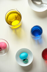 Coloring eggs for Easter celebration on white table