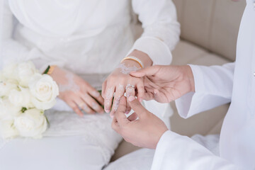 Groom wear wedding rings to left finger of bride, Muslim wedding, Wedding Poster, Close up hand.	
