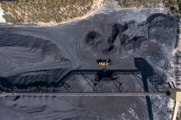 Drone aerial photograph of industrial machinery processing and moving crushed coal in a Colliery in...