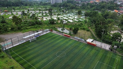 Aerial view of a soccer field with fresh grass in the afternoon