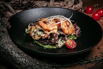 Delicious Shrimp Salad with Vegetables and Sauce on Black Plate, Cherry Tomatoes and Rosemary, Wooden Background with Decor.