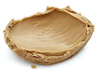 Creamy nut butter artfully spread on a wooden board showcases the rich texture and natural color of the spread