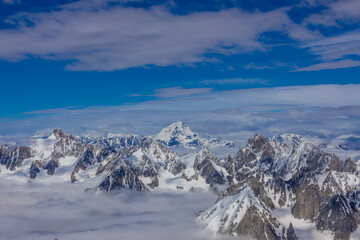 Snow and glacier in the high mountains in the Alps. View of the alpine scenic landscape of rocky summit peaks and glacier ice crevasse from the top of the mountain Aiguille du Midi cable car Chamonix