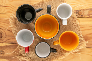 Empty ceramic cups with jute napkin on ceramic tray on wooden table, close-up, top view.