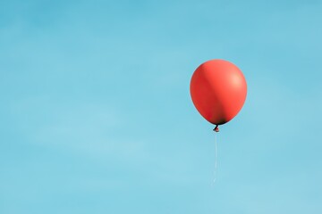 Obraz premium lone red balloon slowly rising against vast blue sky symbolizes inflation providing ample copy space
