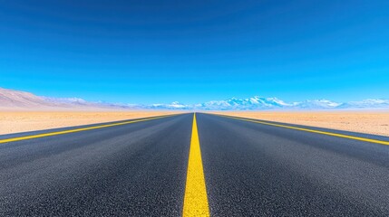 Naklejka premium Endless Asphalt Road Towards Majestic Snowy Mountains Under a Vibrant Blue Sky