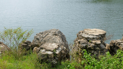 View of limestone formations on the edge of the lake.Copy space for text.Limestone and green grass.Ecology and environmental concept.For graphic design,3D rendering or banner background