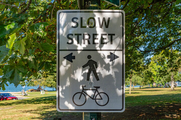 Slow Street Sign which is aa residential street designed to prioritize pedestrians and cyclists,...