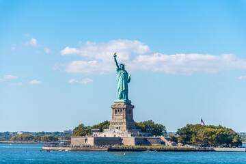 World famous Statue of Liberty under a blue sky with white clouds