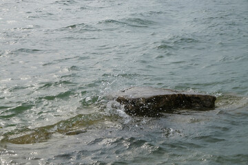 Fototapeta premium Limestone rocks submerged in lake water.The lake water looks clear. Looks calm and peaceful for relaxation. Copy space. Ecological and environmental concepts. For graphic design or 3D rendering 