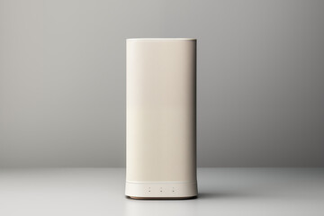 A modern cylindrical lamp stands elegantly on a minimalist table, showcasing its sleek design against a neutral gray background, suitable for various interior settings.