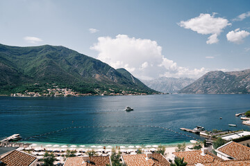 View over the brown roofs of hotels to a boat sailing on the sea