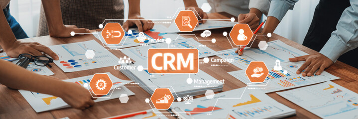 A diverse team collaborates on customer relationship management strategies using visual data analysis at a modern workspace. Engaged discussion and planning drive success. Amity