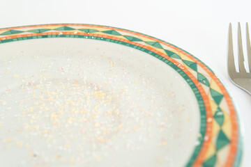 plate with real microplastic particles and fork. Problem of plastic particles in food, concept, health problems, cancer, kidney disease and serious environmental pollution. Close up