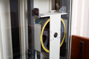 Modern elevator pulley. Glass lift or elevator in building. Rope or steel cable pulley. Elevator...