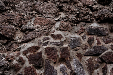 A wall made of stone with a rough texture. The wall is brown and white
