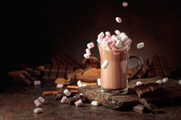 Marshmallows are poured into a mug of hot chocolate drink.