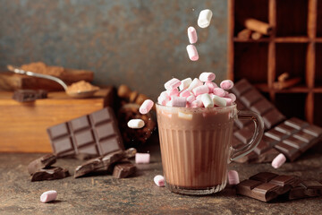 Marshmallows are poured into a mug of hot chocolate drink.