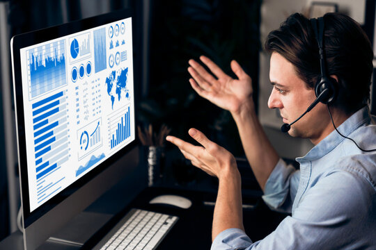 Call center consulting with customers on headphones on monitor in business paragraph with typing on pc with dynamic data marketing analysis planning at modern home office at night time. Pecuniary.