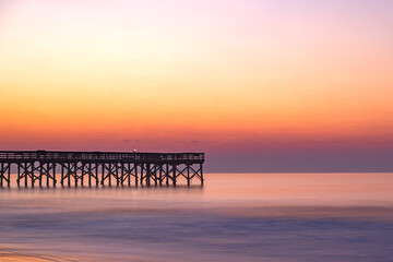 Sunrise over the pier at Isle of Palms, SC, USA.