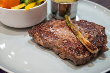 Large beef rib eye steak grilled on gas stove in German restaurant